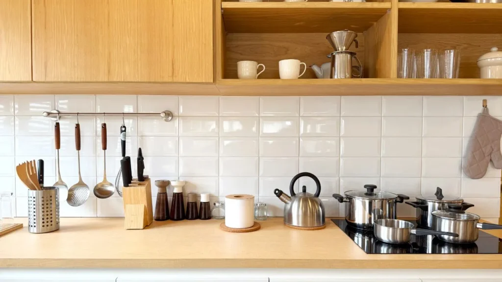 Clean subway tile backsplash and wooden countertop organized with stainless steel cookware, a pour-over coffee dripper, and everyday kitchen gadgets to make life easier
