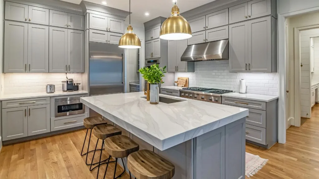 Luxury home interior displaying a stunning paint grey kitchen cabinets makeover complemented by brass dome pendants and a marble waterfall island.