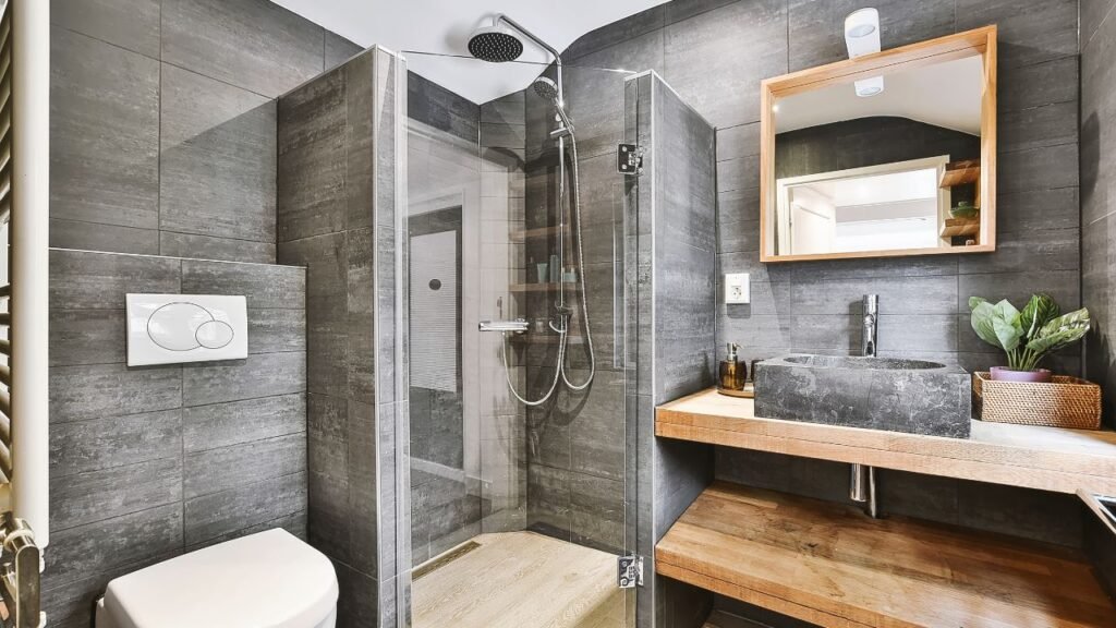 Modern bathroom decorations featuring a freestanding oval tub, dark tile walls, and warm wood flooring