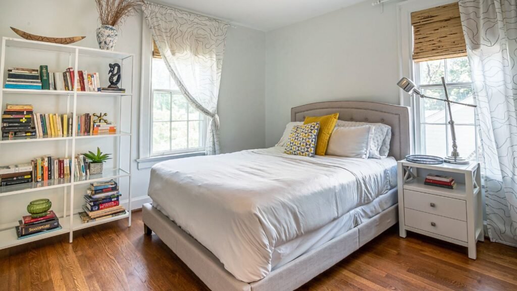A cozy, textured space with glowing string lights and a large monstera plant, demonstrating a relaxing bed placement feng shui bedroom setup that promotes peaceful energy.