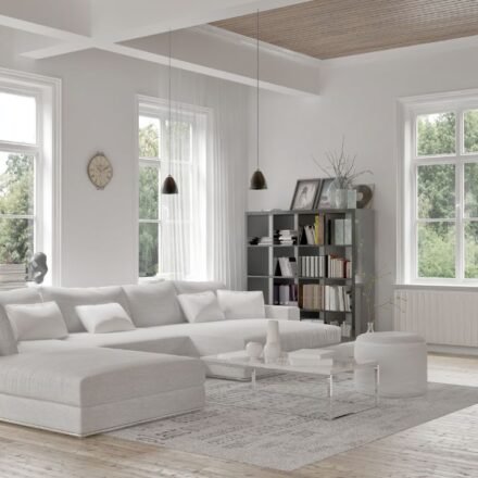 Elegant gray living room with wainscoting wall paneling, framed botanical prints, twin round coffee tables, and herringbone wood flooring