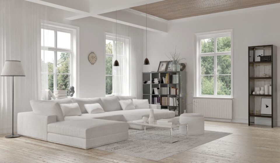 Elegant gray living room with wainscoting wall paneling, framed botanical prints, twin round coffee tables, and herringbone wood flooring