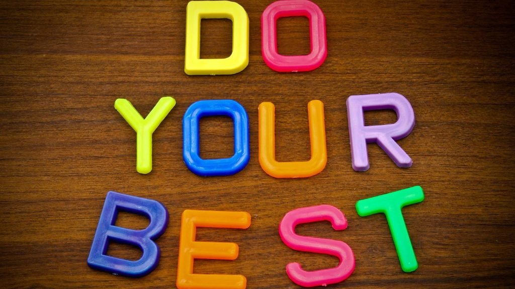 Colorful plastic letters spelling "Do Your Best" on a wooden surface, a motivational bedroom decor idea