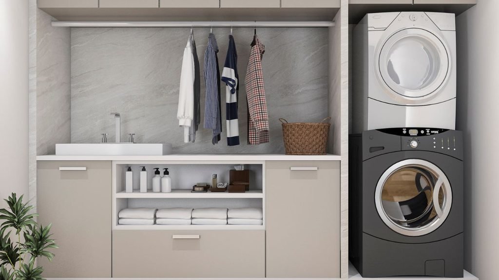Stylish laundry room with stacked washer and dryer, hanging shirts, folded towels, and a wall-mounted sink
