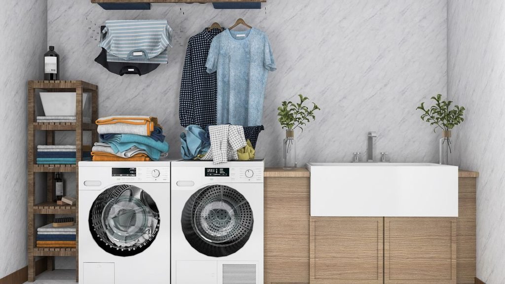 Modern laundry room with stacked washer and dryer, folded towels, and hanging clothes beside a farmhouse sink