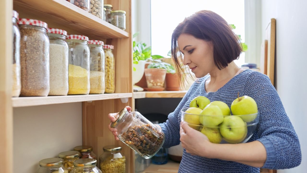 Clear stackable bins on a small kitchen pantry shelf