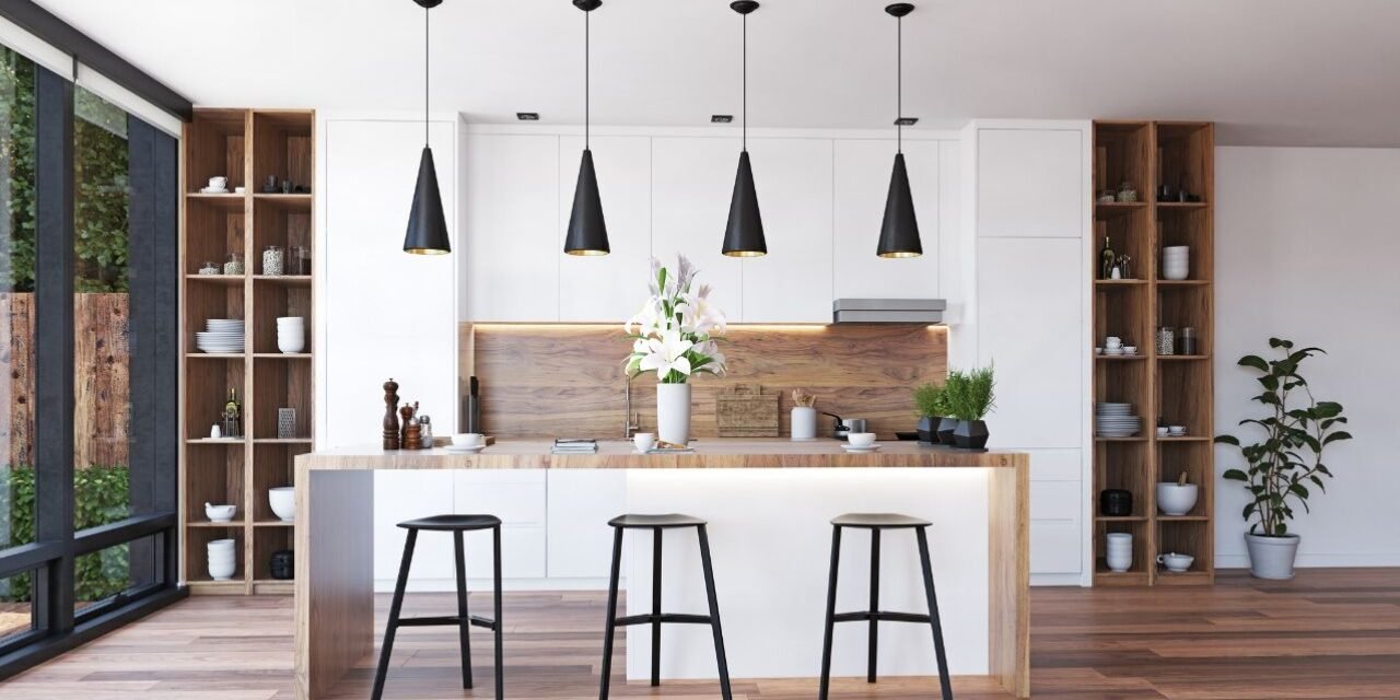 Four black cone pendant lights with gold interiors above a wood-and-white island in a modern kitchen