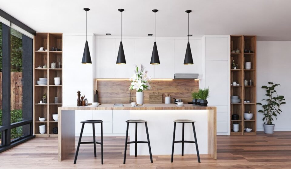 Four black cone pendant lights with gold interiors above a wood-and-white island in a modern kitchen