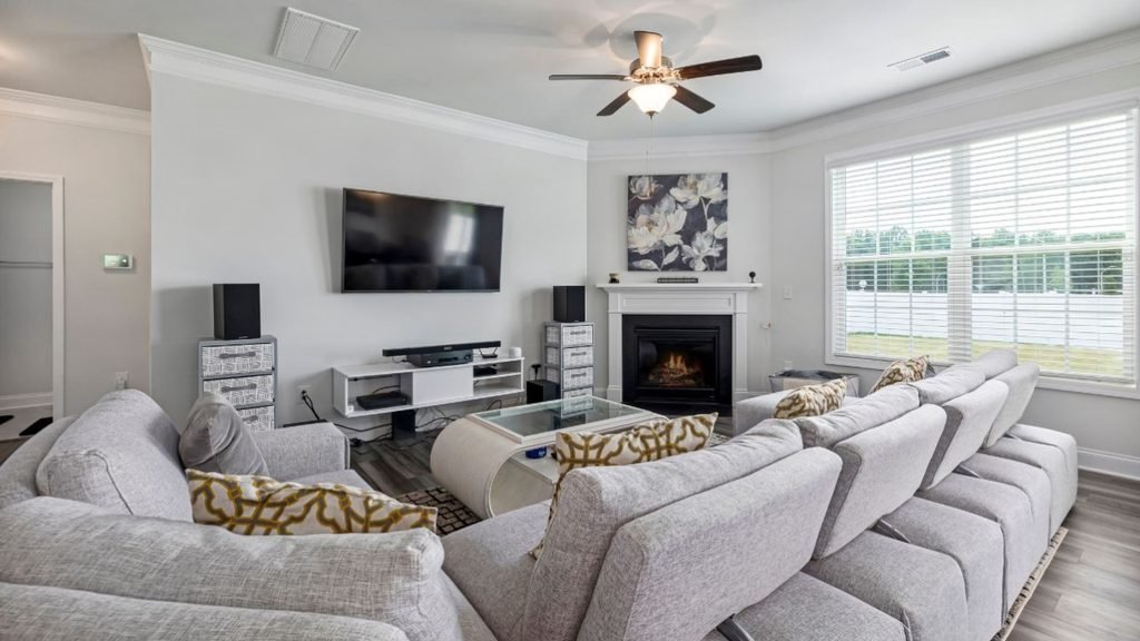 Cozy living room with a bright bay window, gray linen sofas, textured pillows and a tall fiddle leaf fig.