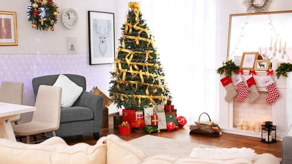 DIY Christmas living room decorations with a gold ribbon tree, personalized stockings on a white mantel and wrapped gifts