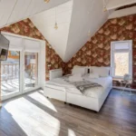 Cozy attic bedroom with vintage floral wallpaper for wall designs and bright natural lighting.