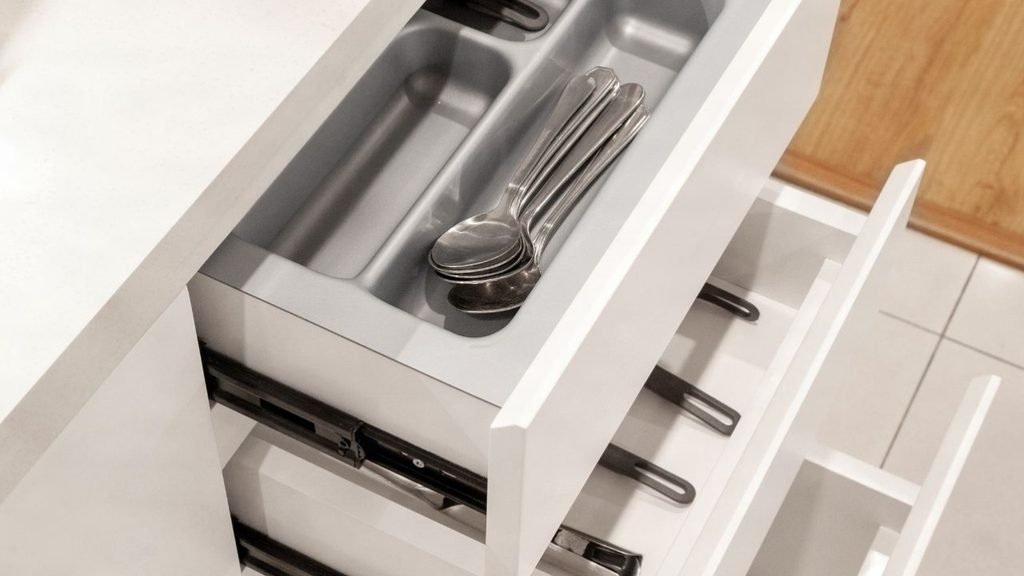 Kitchen cabinet drawer organization with a cleaning organizer tray sorting whisks, scissors, peeler, knives and baking tools into compartments