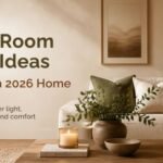 Warm, cozy living room with a neutral sofa, layered textures, greenery, and soft ambient lighting