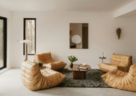 Minimalist cosy interior living room with a beige sectional sofa, floor-to-ceiling windows, built-in bookshelves and green plants