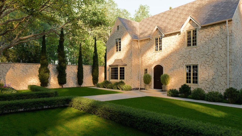 Sunlit stone house exterior with irregular fieldstone walls, dormer windows, trimmed hedges and a matching stone garden wall
