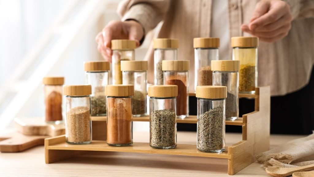 Tiered acrylic spice organizer displaying spice jars in alphabetical order