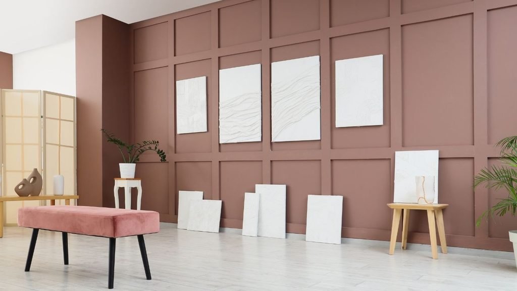 Wainscoting and beadboard styles shown with a mauve grid panel molding accent wall and textured white art canvases