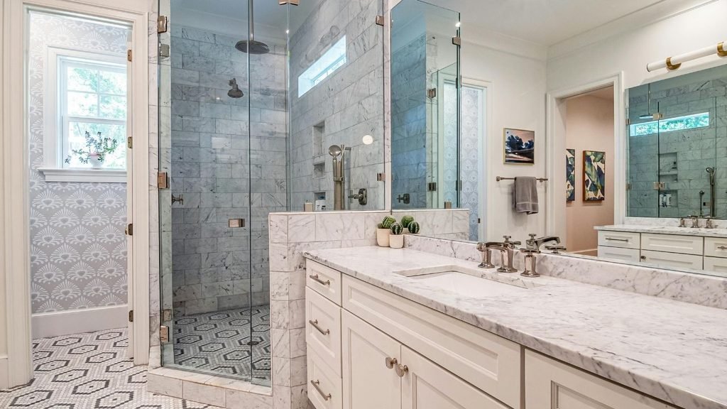 Bathroom with marble tile, a glass shower and white vanity, an alternative to wainscoting beadboard panels for bathrooms